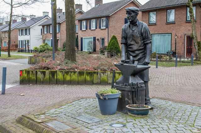 Foto van het beeld van de spijkermaker op het Piet van Thielplein in Beek en Donk