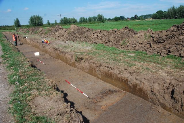 Archeologen van Vestigia op zoek naar de limesweg. Op de voorgrond de donkere baan van de Romeinse bermsloot, op de achtergrond de spoorlijn Alphen –Bodegraven.