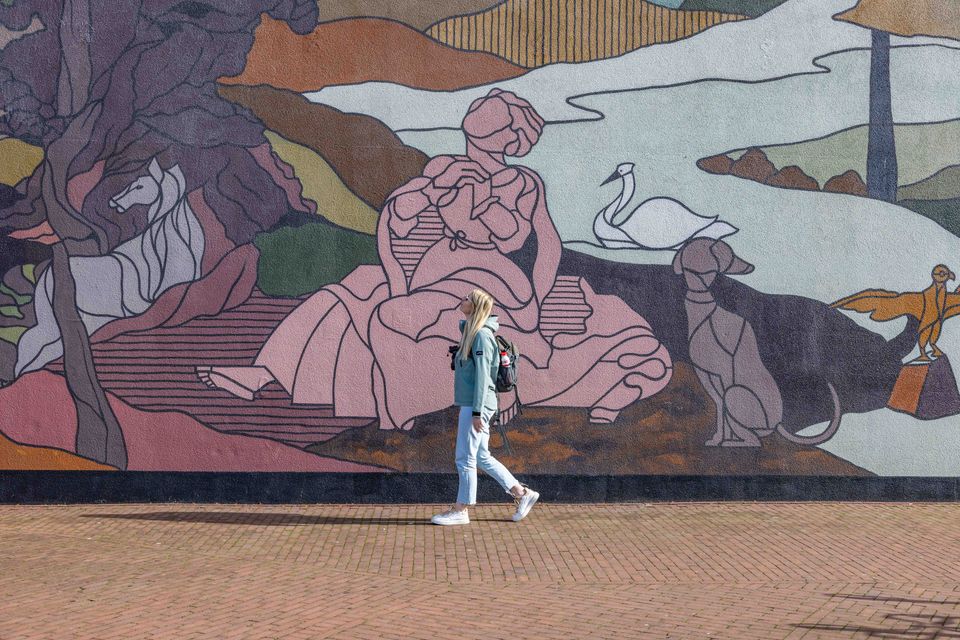 Meisje voor mural op bibliotheekmuur