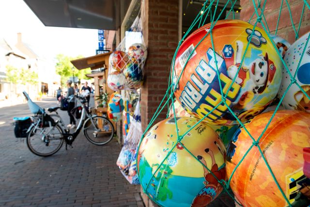Een winkel met buiten ballen in een net en fietsen
