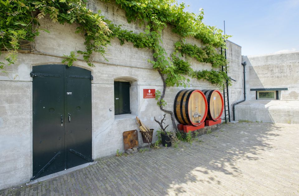 Fort aan de Drecht twee stukken wijnvaten tegen een muur met rode rand.