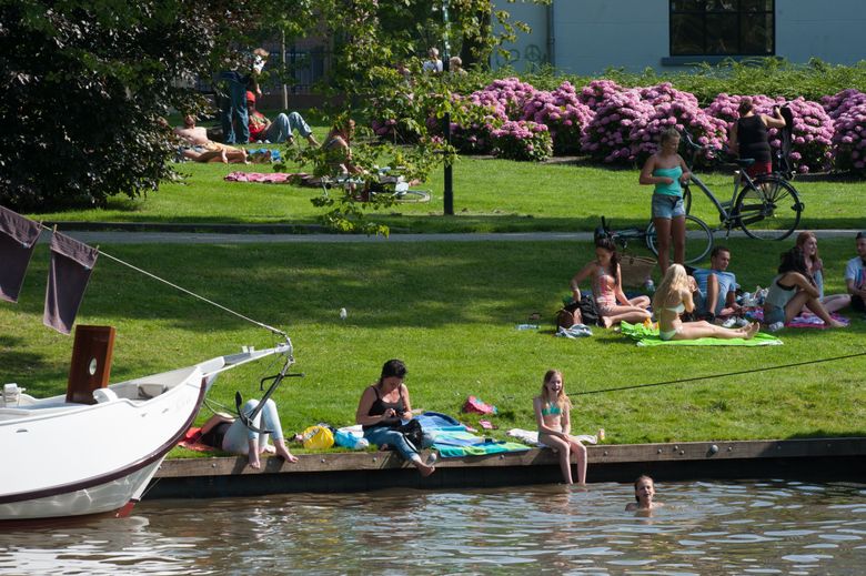 Mensen genieten van het mooie weer in de Prinsentuin in Leeuwarden