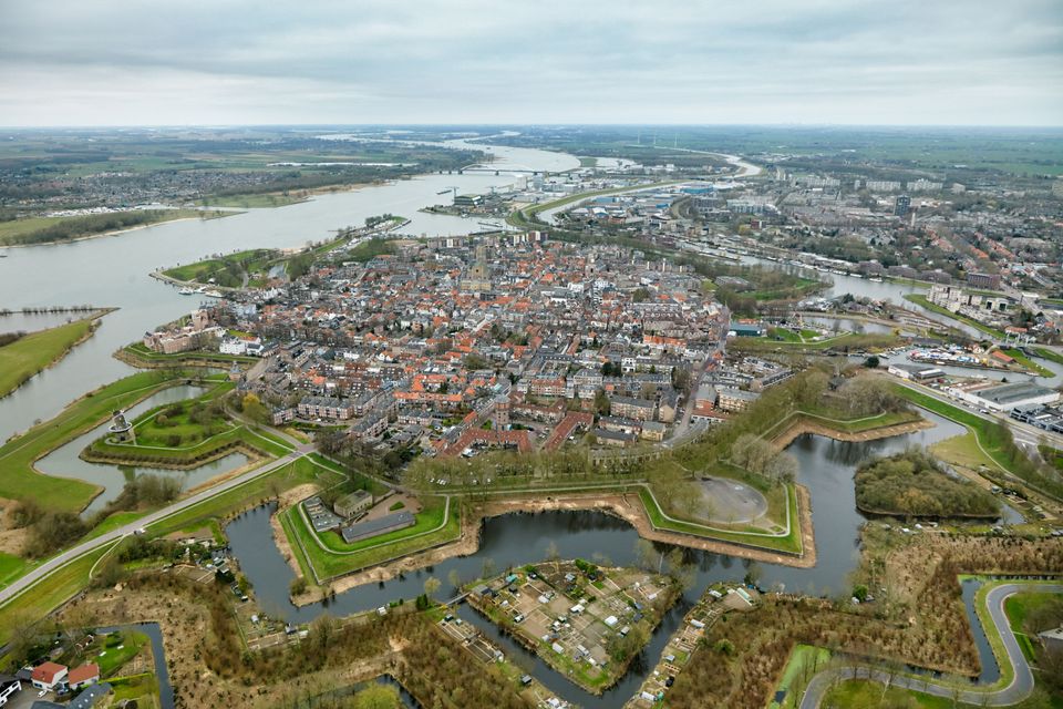 Een vestingstad met een typische stervorm aan een rivier, gefotografeerd vanuit de lucht.