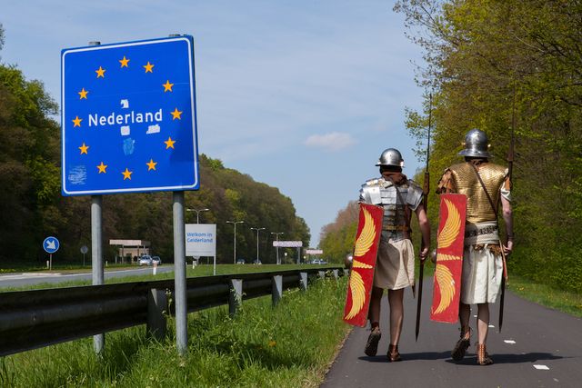 Romeinen bij Nederlands grensbord
