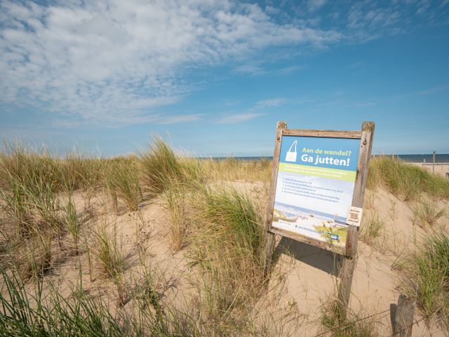 Informatiebord over Grondstofjutten in Katwijk aan Zee, samen het strand schoonhouden.