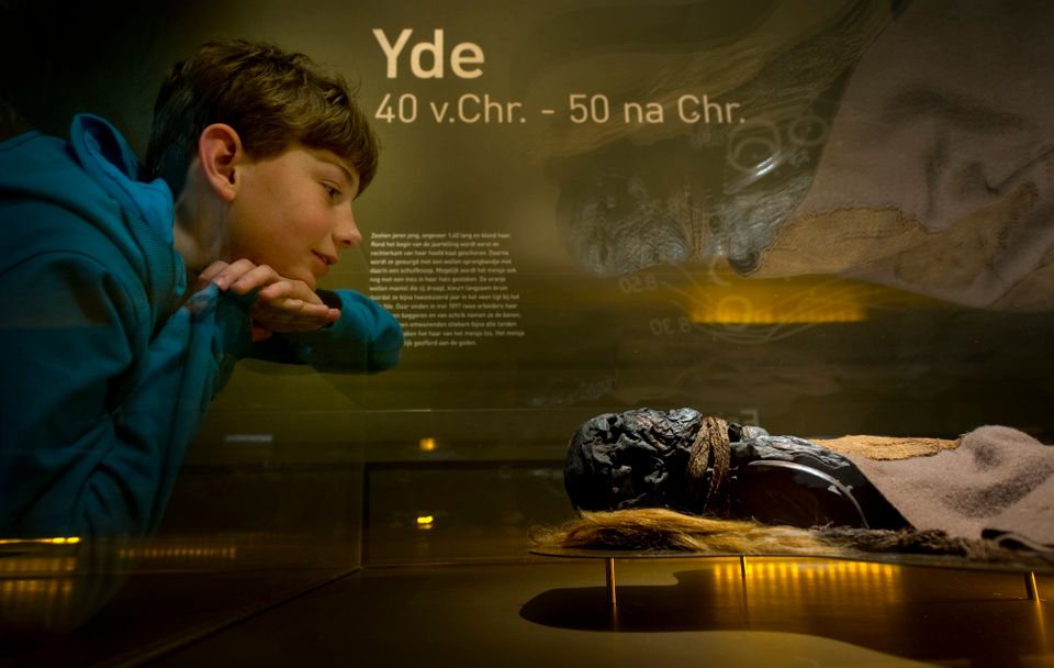 Een jongen kijkt naar het meisje van Yde in het Drents Museum.