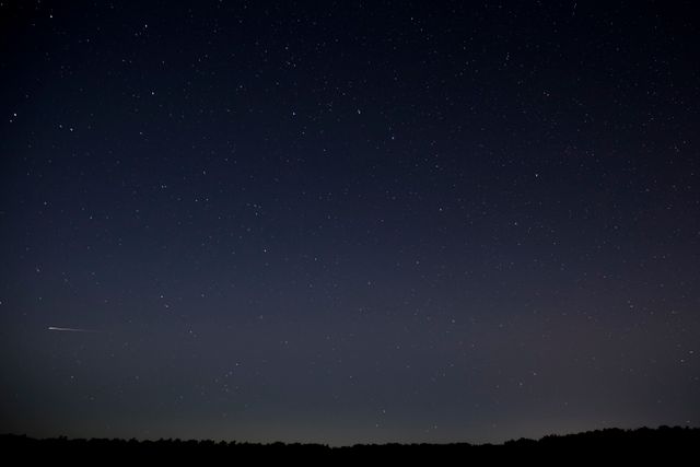 De sterrenhemel in Drenthe met vallende ster.