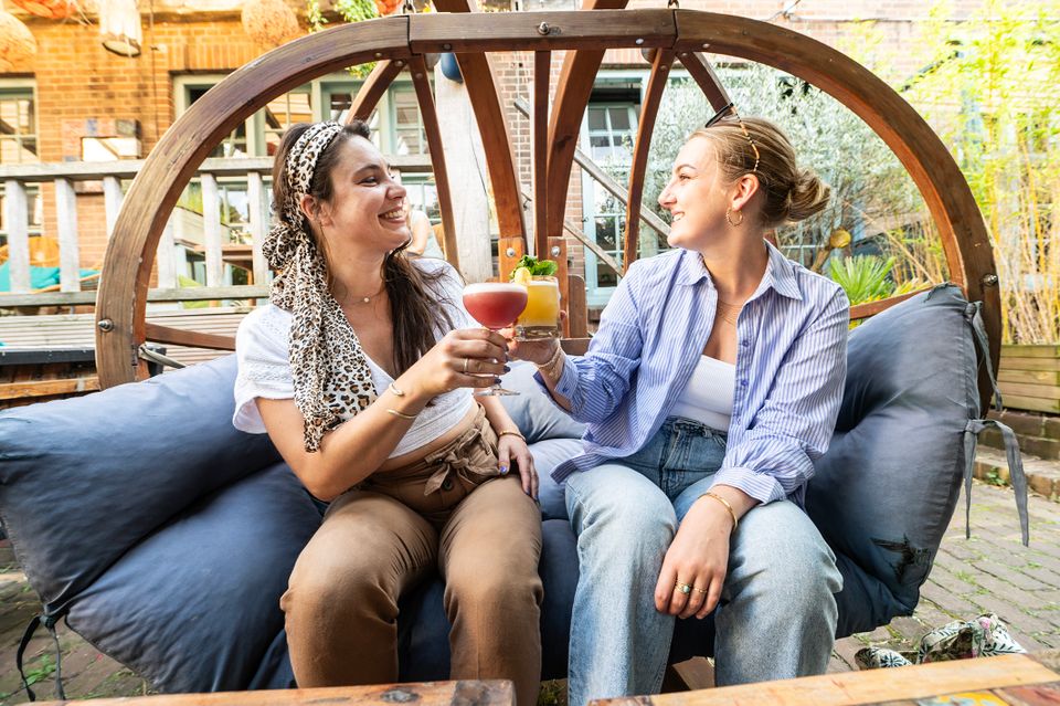 Twee jongedames proosten met cocktails in de lente in Delft