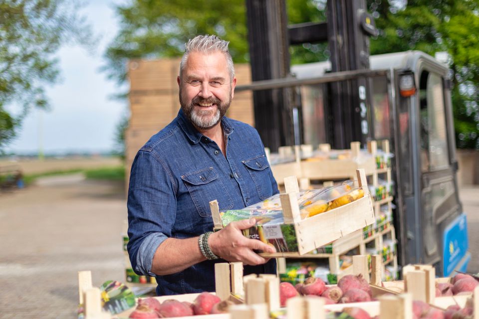 Een man laadt fruitkistjes uit in Flevoland