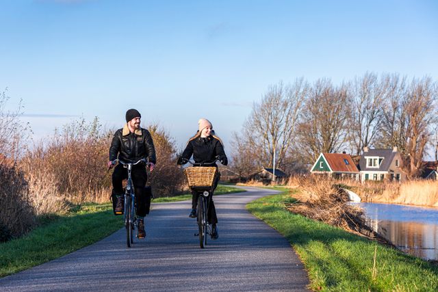 Een man en vrouw fietsen samen in de winter in Zuidwest Friesland