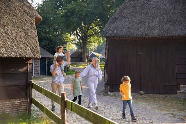 Een gezin wandelt op een zomerse dag door monumentendorp Orvelte.