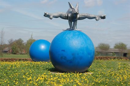 Kunstwerk mens-haas springt over blauwe bal