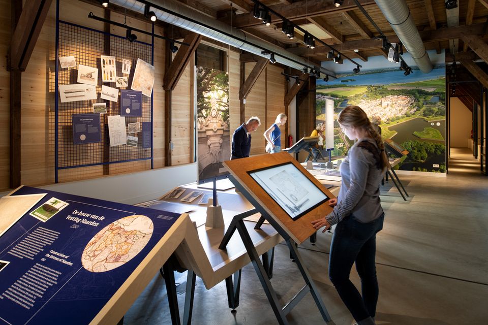 Bezoekers bekijken de tentoonstelling in bezoekerscentrum de Gele Loods in Naarden.