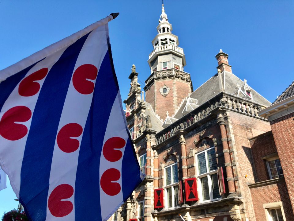 friese vlag en het stadhuis van bolsward op de achtergrond