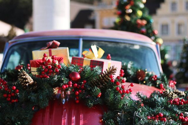 Kerstig versierde auto met cadeautjes en guirlande