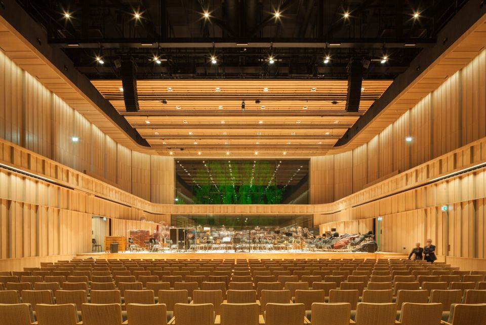 Het interieur van een grote auditorium met houten wanden.