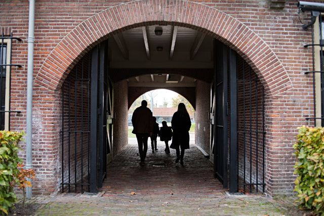 Een gezin loopt door de poort van het Gevangenismuseum in Veenhuizen.