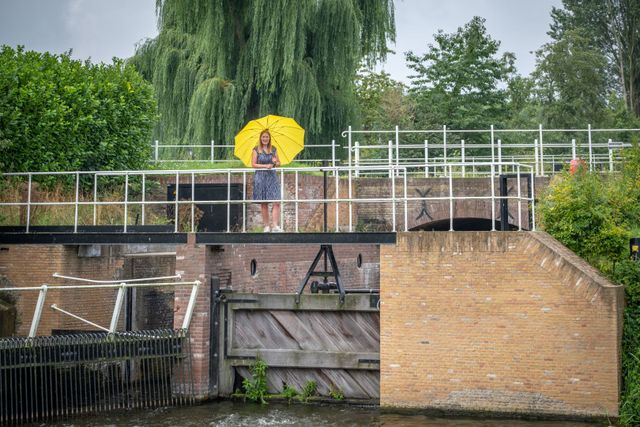 Foto van de Keenesluis bij Standdaarbuiten met een mevrouw bovenop de brug bij de sluis