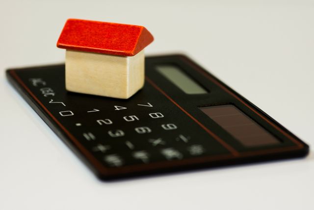 Wooden house on a calculator