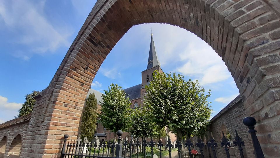 Sint Willibrorduskerk Deurne doorkijkje met monumentale kerkhofmuur
