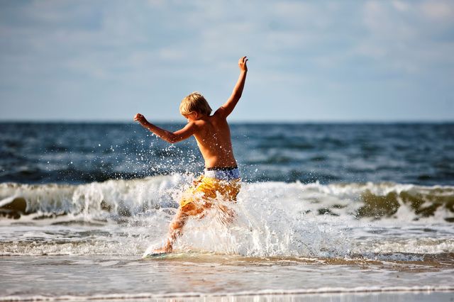 Jongen kind surft met opspattend water  (Small)