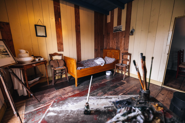 De kamer waar Van Gogh gewoond en gewerkt heeft in Drenthe met het bed, stoelen, een wastafel en schildersgerei.