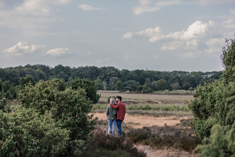 Bei einem Wanderung blickt ein Paar über die 
weite landschaft von Drenthe.