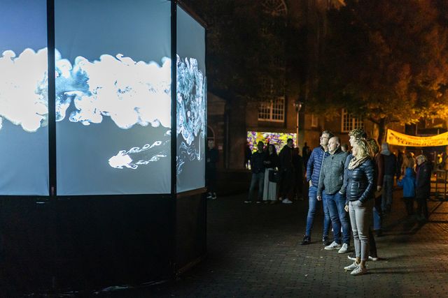 publiek luna lichtfestival kijkt naar een scherm op straat