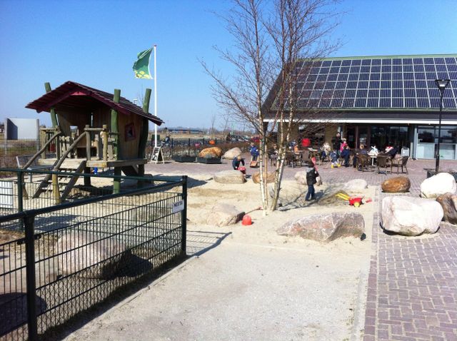 Stadsboerderij de Wiedemolen met huisje voor kinderen om in te spelen en een zandbak.