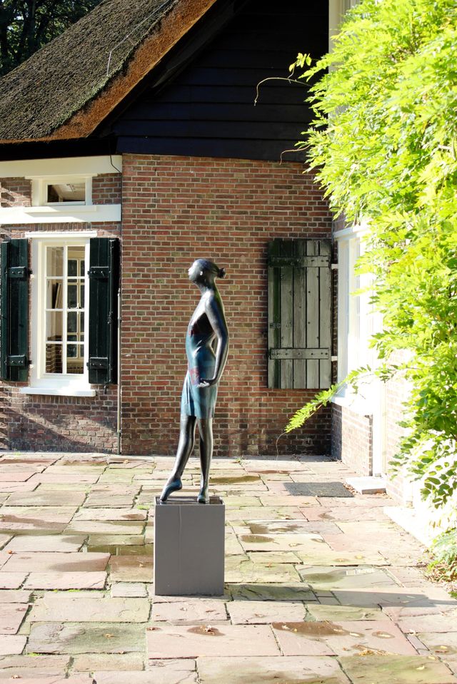 Een beeldhouwwerk van vrouw in de tuin van Galerie Wildevuur