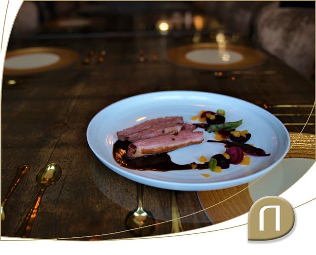 Een bereide eendenborstfilet ligt op een bord in Restaurant Narline klaar om gegeten te worden.