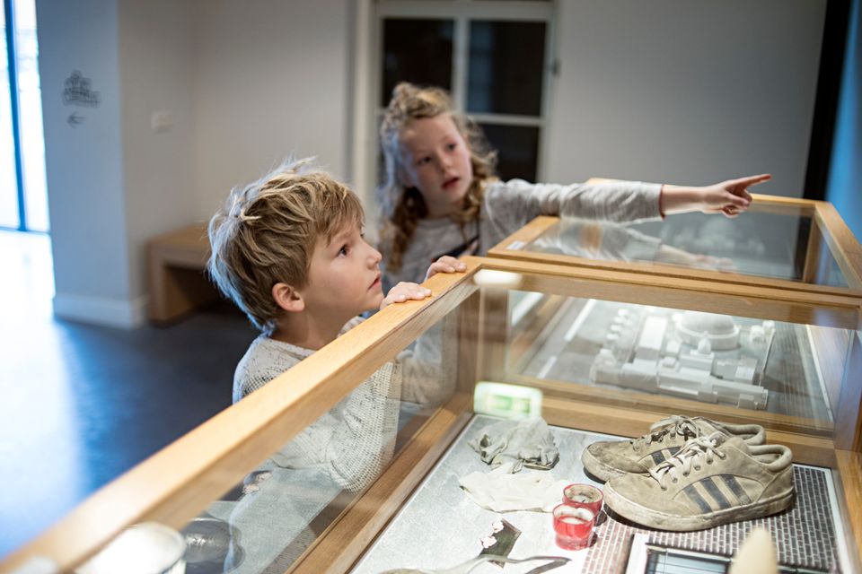 Een jongen en meisje kijken naar tentoongestelde stukken in het gevangenismuseum.