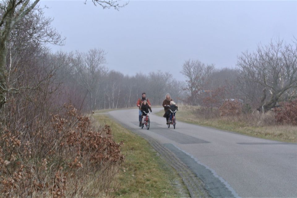 Stel ouders fietsend met kinderen op Postweg Vlieland