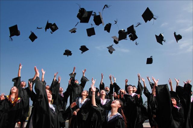Students graduating and throwing their caps