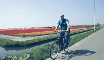 Buurtzorg Nederland op de fiets langs een bollenveld