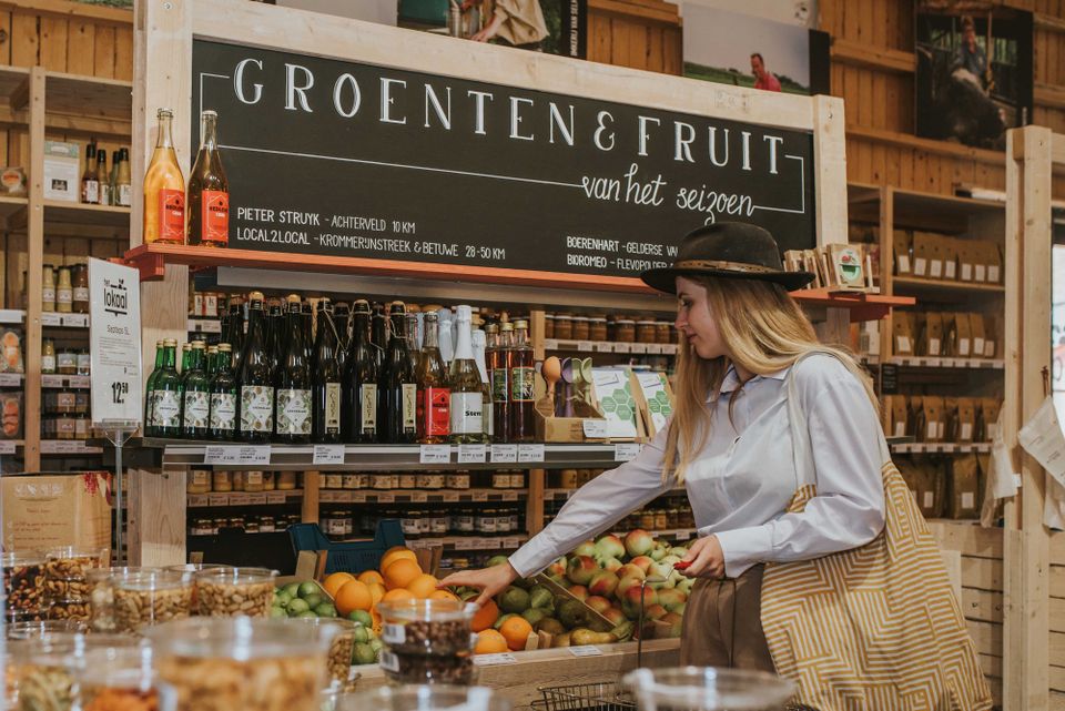 Markten Amersfoort - Oliemolenhof - Streekproducten vrouw die sinaasappel pakt
