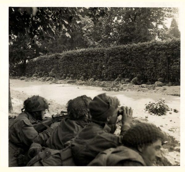 Op deze foto zijn de militairen van No. 15 en No. 16 Platoon te zien. Zeventien militairen zitten in positie bij de heg van de Van Lennepweg 14 en steken hun geweren door de heg heen (Imperial War Museum).
