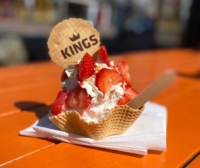 Een heerlijk ijsje met verse aardbei in een bakje van Kings Ijscafé
