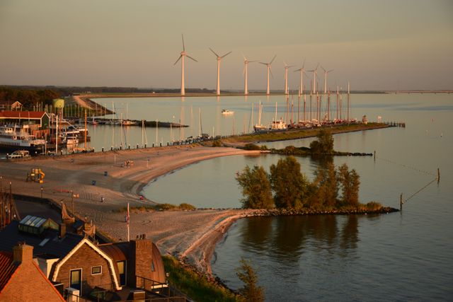 Een strand, water en windmolens in de haven in Urk, Flevoland