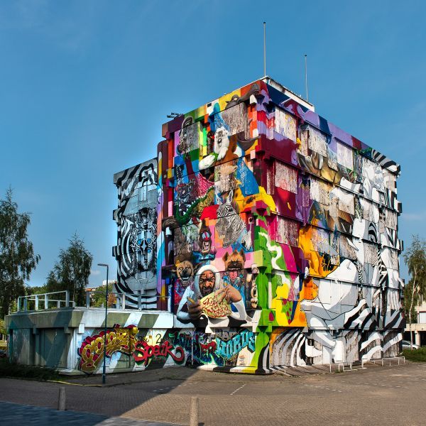 Street art kunstwerk op oud kantoorgebouw met veel gekleurde muurschilderingen.
