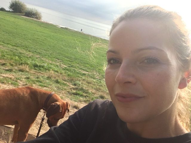 selfie van een mevrouw 
op de achtergrond een hond en een meer