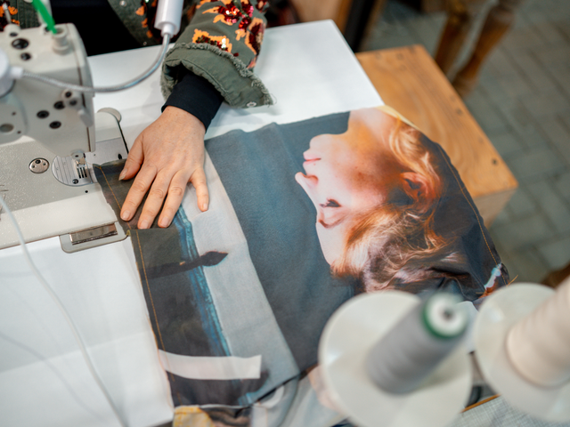 Vermeer Recycle Project ontwerper Marieke die met een naaimachine stoffen van een vlag aan het naaien is