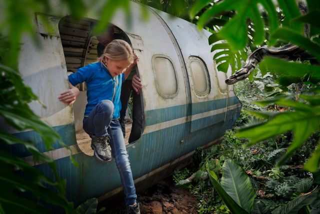 Een meisje stapt uit het wrak van een vliegtuig in Wildlands Adventure Zoo.