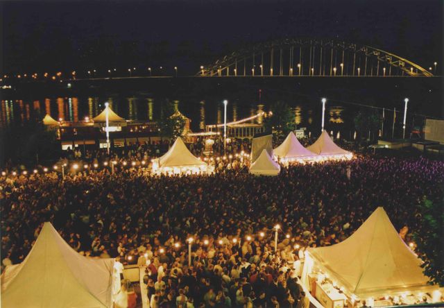Beschrijving	32e Vierdaagsefeesten. Gezicht op het volle evenementenplein voor het Holland Casino op de slotavond met op de achtergrond de (verlichte) Waalbrug.
Datering	20/7/2001