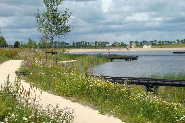 Landschap in de Wellerwaard met een wandelpad, water, steiger en strand in Emmeloord, Flevoland