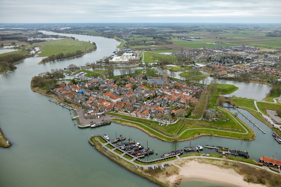 Een vestingstad aan een rivier gefotografeerd vanuit de lucht.