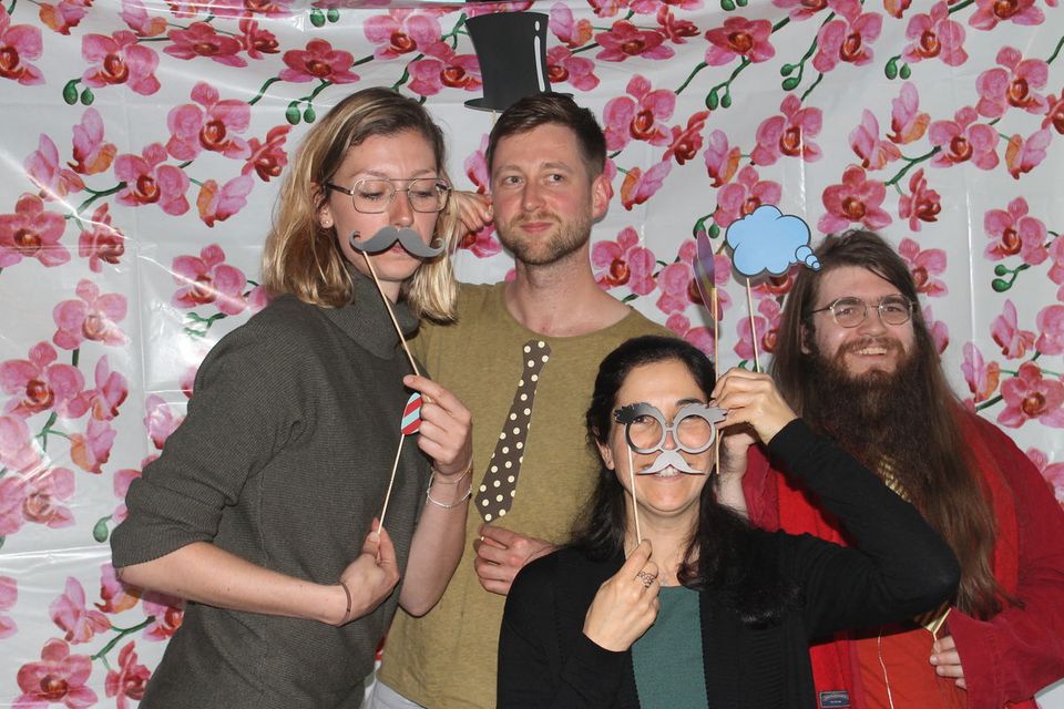 Four people posing for a photo at a party