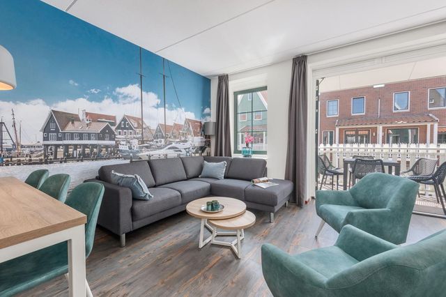 Een foto van één van de kamers van hotel marinapark met als behang een beeld van de haven van Volendam