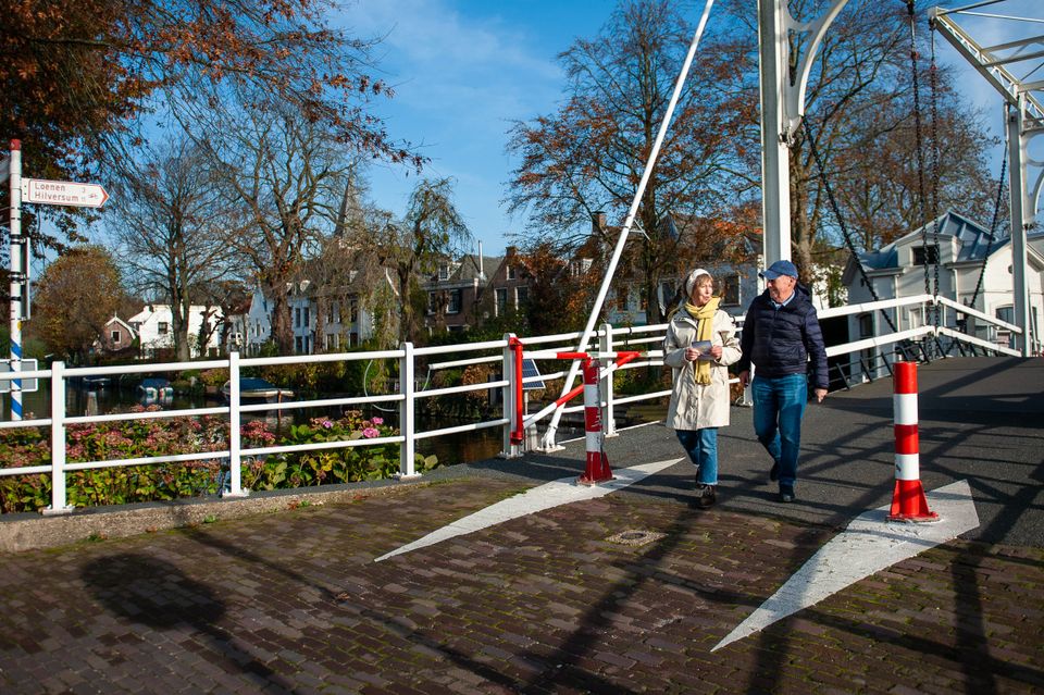 Ouder stel wandelt over de brug bij Loenen aan de Vecht