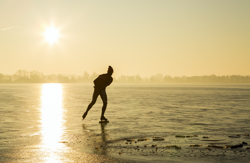 een man aan het schaatsen op een meer